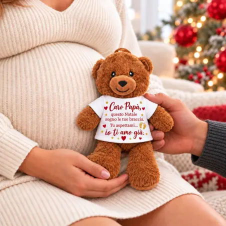 Orsetto Caro papà con dedica natalizia rossa e oro, tenuto vicino al pancione della mamma con la mano del futuro papà
